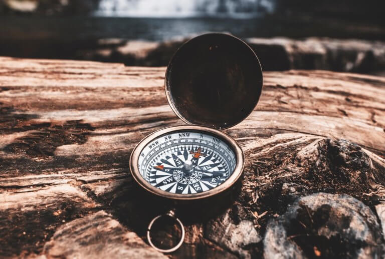 Brown compass on wood - finding yourself Ad Florem